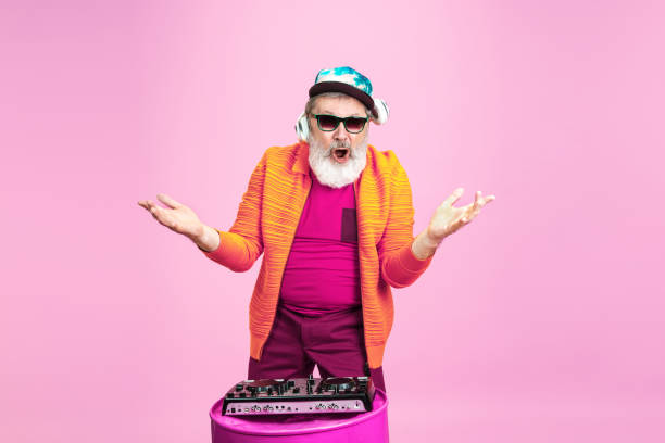 istock Senior hipster man wearing eyeglasses posing on pink background. Tech and joyful elderly lifestyle concept 1269810635