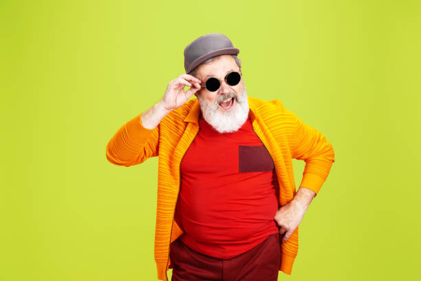 istock Senior hipster man wearing eyeglasses posing on green background. Tech and joyful elderly lifestyle concept 1269810636