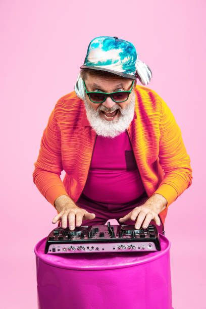 istock Senior hipster man wearing eyeglasses posing on pink background. Tech and joyful elderly lifestyle concept 1269810639