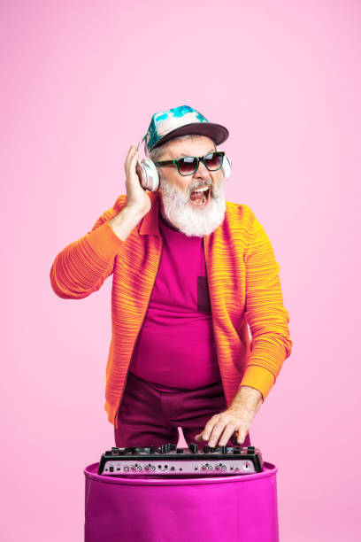 istock Senior hipster man wearing eyeglasses posing on pink background. Tech and joyful elderly lifestyle concept 1269810642