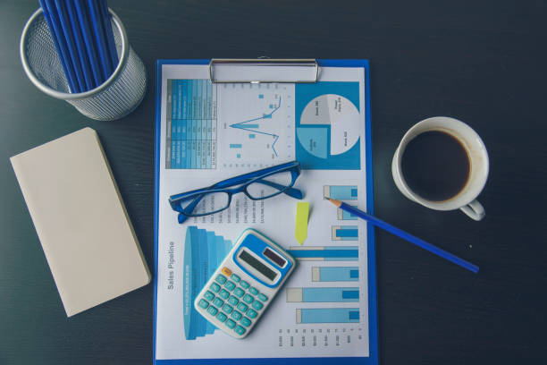 istock Office laptop business financial document chart and graph on wooden table with coffee cup. Flat lay notebook computer laptop on office desk. No people business graph chart mockup on business workspace 1269810813