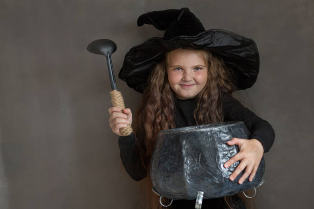 istock Happy girl in halloween witch costume brew a portion 1269810886