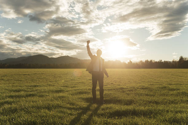 istock Businessman celebrating success standing in a meadow 1269811674