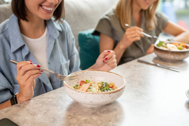 istock Young smiling female client of cafe or restaurant holding fork over salad 1269814532