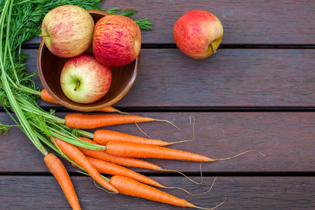 istock Carrots and apples on the wood 1269815124