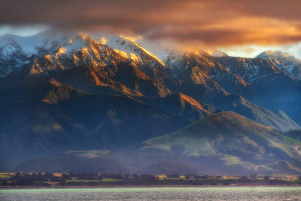 die seaward kaikoura range und der strand von kaikoura am morgen in neuseeland - marlborough region sunrise new zealand sea stock-fotos und bilder