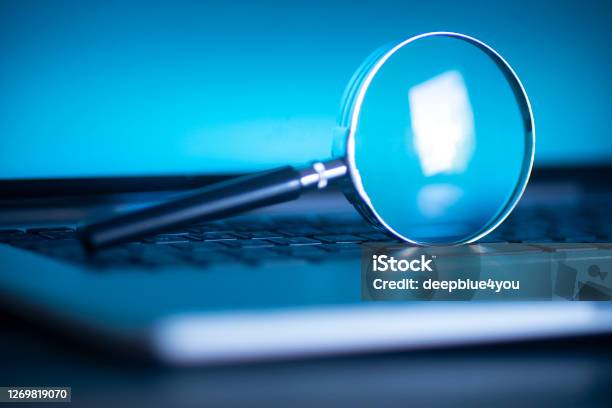 Laptop Computer With Magnifying Glass As A Symbol For Searching Information On The Internet Stock Photo - Download Image Now