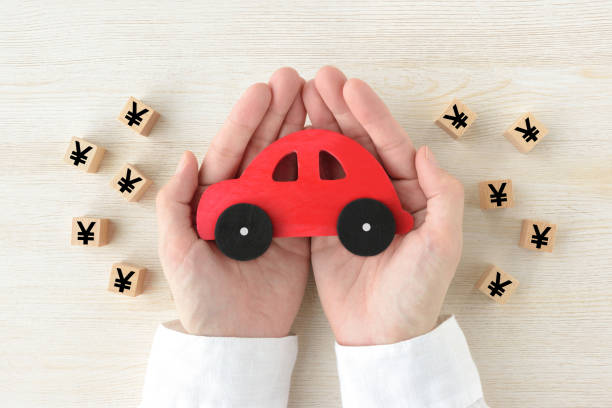 Red car toy surrounded by human's hands wooden blocks with Japanese yen marks Red car toy surrounded by human's hands wooden blocks with Japanese yen marks lorne stock pictures, royalty-free photos & images