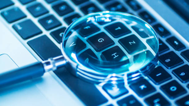 Laptop computer with magnifying glass as a symbol for searching information on the internet