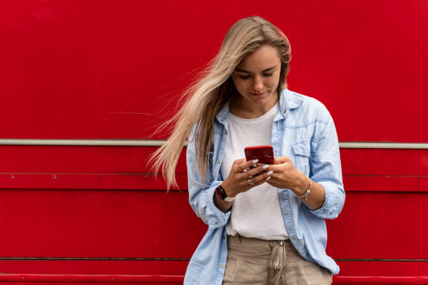 istock Happy blonde woman using mobile phone, texting messeges or making video call 1269821667