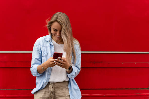 istock Happy woman texting on her cell phone 1269821688