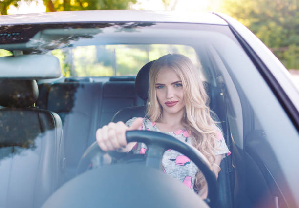 istock A young pretty girl is driving a car. 1269822752