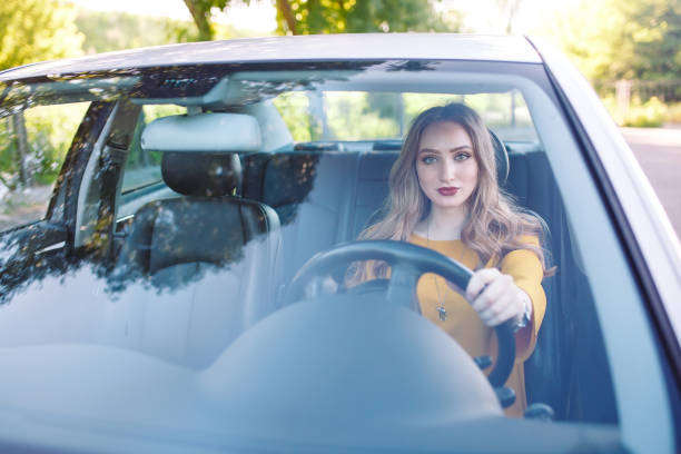 istock A young pretty girl is driving a car. 1269822774