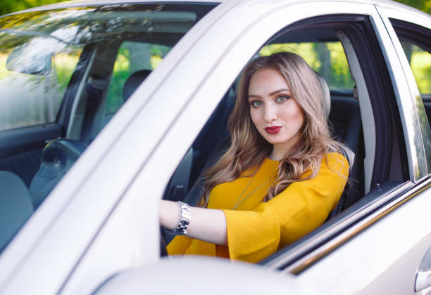istock A young pretty girl is driving a car. 1269822784