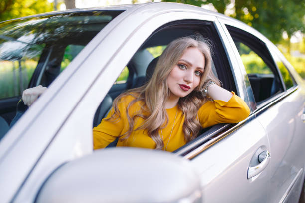 istock A young pretty girl is driving a car. 1269822795