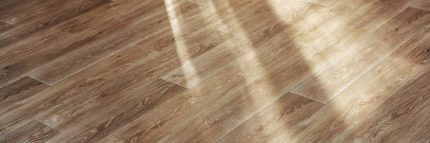 istock wooden laminate floor with shadows from window light inside 1269823420