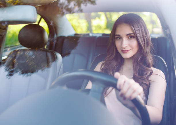 istock A young pretty girl is driving a car. 1269823466