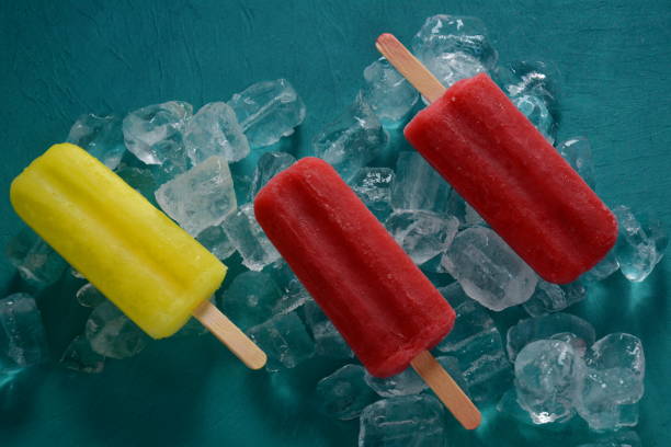 istock Strawberry popsicle and lemon popsicle on blue background with ice 1269827047