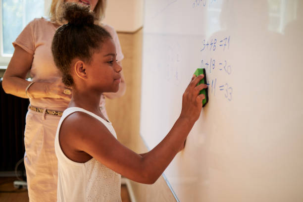 istock After she successfully solve the math problem smart school girl cleaning the whiteboard with board eraser 1269827644