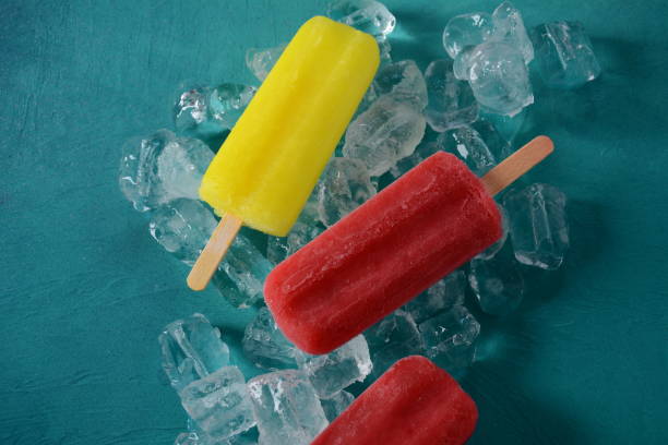 istock Strawberry popsicle and lemon popsicle on blue background with ice 1269827693