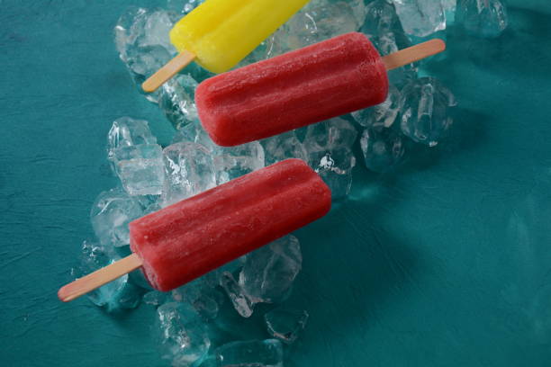 istock Strawberry popsicle and lemon popsicle on blue background with ice 1269827746
