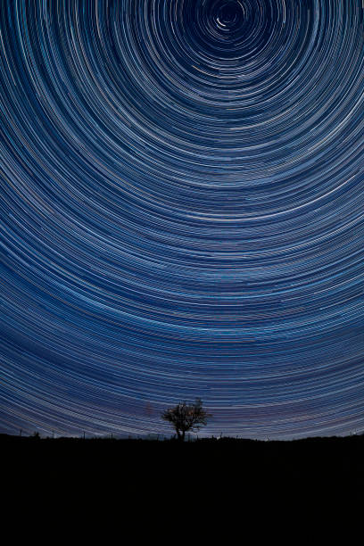 istock Digital composite image of star trails around Polaris with Beautiful Autumn Fall landscape vibrant countryside image of lone tree and stone wall 1269828385