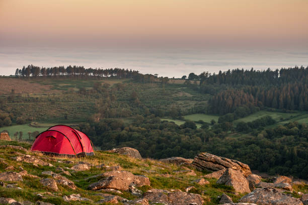 impresionante imagen de camping salvaje en el campo inglés durante el impresionante amanecer de verano con cálido resplandor del sol iluminando el paisaje - dartmoor fotografías e imágenes de stock