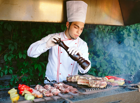 The Chef prepares meat on the barbecue
