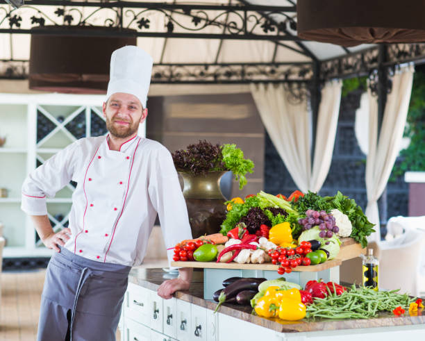 istock Portrait of a Chef with vegetables on the table. 1269829278
