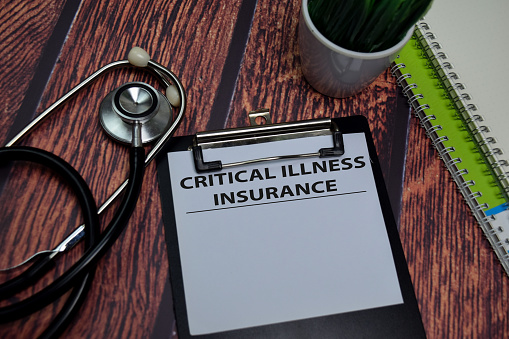 Critical Illness Insurance write on paperwork isolated on wooden table.