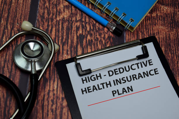 istock High Deductive Health Insurance Plan write on paperwork isolated on wooden table. 1269830044
