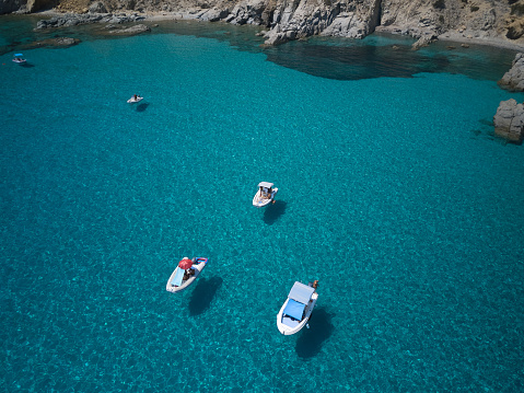 aerial view of sardinia shoreline with boat and crystal clear blue turquoise sea - (Cala Sirena ) TRAVEL in SARDINIA