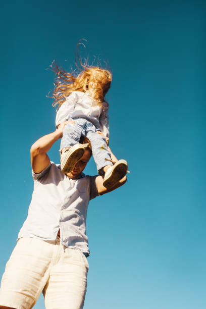 istock Father and daughter on sky background. 1269831100