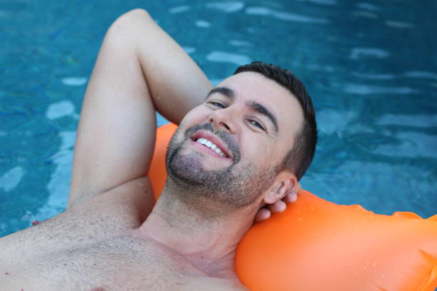 istock Man relaxing in swimming pool 1269832270