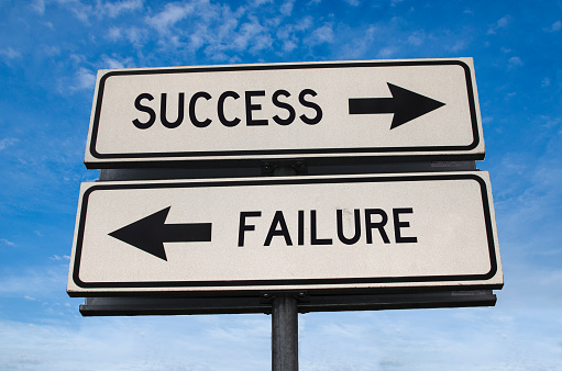 Success vs failure. White two street signs with arrow on metal pole with word. Directional road. Crossroads Road Sign, Two Arrow. Blue sky background. Two way road sign with text.