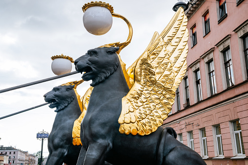 Sculpture at the top of a fountain in the Place de la Sinne, in the french town of Ribeauville. In the background appear the tower of a church.