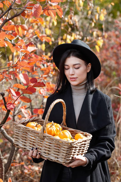istock Woman in black with Halloween pumpkins 1269836325