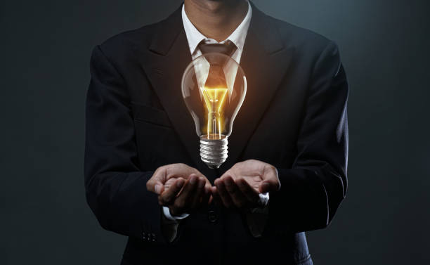 istock Glowing Bulb Floating on Businessman Hand. Stand Out Idea Concept 1269836818