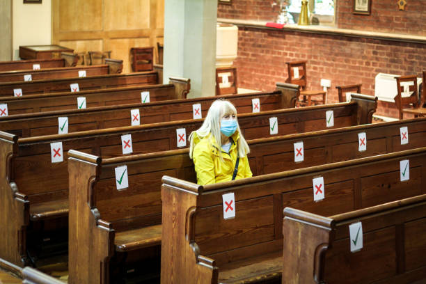 mujer mayor rezando en la iglesia usando máscara protectora para la cara - senior women caucasian one person religion fotografías e imágenes de stock