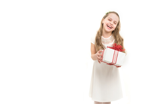Holiday celebration and mothers day. Christmas and birthday. Childhood and happiness. Child or happy kid with present pack isolated on white background. Small girl with gift box with red bow in dress.