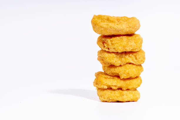 Chicken nuggets side view Chicken nuggets stack isolated on white background. Fast junk food side view with copy space nugget photos stock pictures, royalty-free photos & images