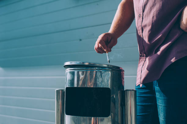 istock A guy with a cigarette in his hands throws it in the trash. 1269841443