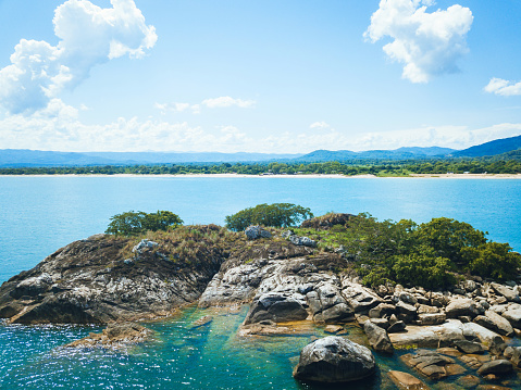 view on the coast of lake malawi with tiny island in the foreground