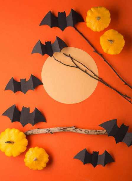 istock Halloween paper decorations, orange background. Black bats, pumpkins, tree branch and moon. Halloween concept. 1269847501