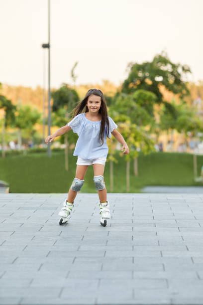 istock little girl rollerskating in summer park. 1269851595