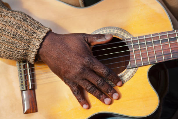 Black hand on acoustic guitar