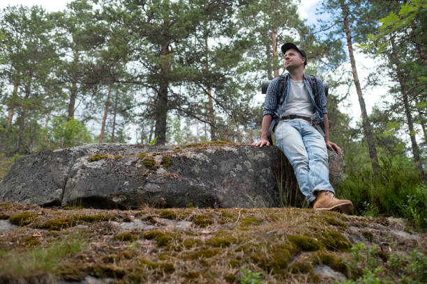 istock Young caucasian man hiking in forest having a rest 1269858213