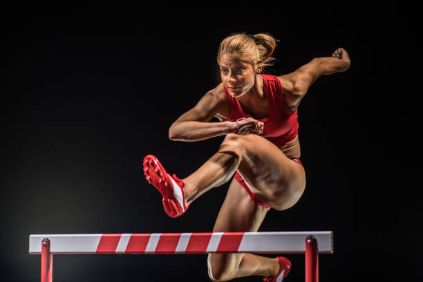 atleta caucásica saltando sobre un obstáculo - hurdling usa hurdle track event fotografías e imágenes de stock