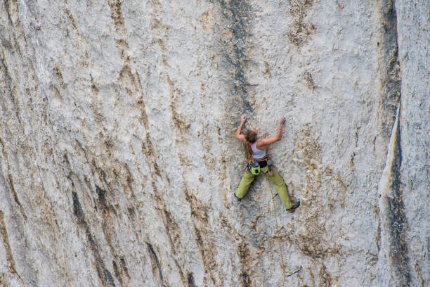 istock Woman free climbing a limestone wall 1269858327