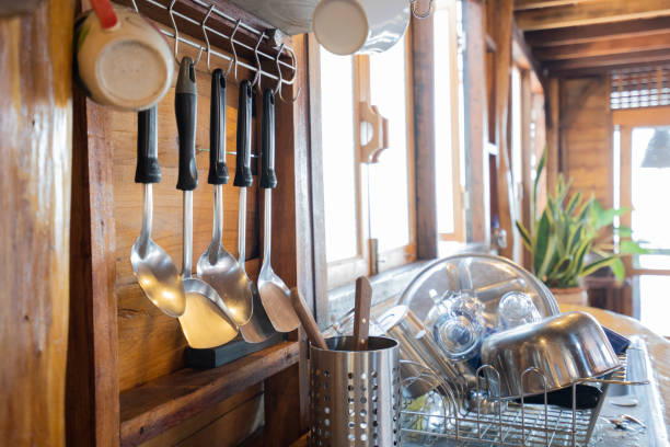 istock Kitchen utensils hanging on wall near kitchen sink with dishes 1269858535